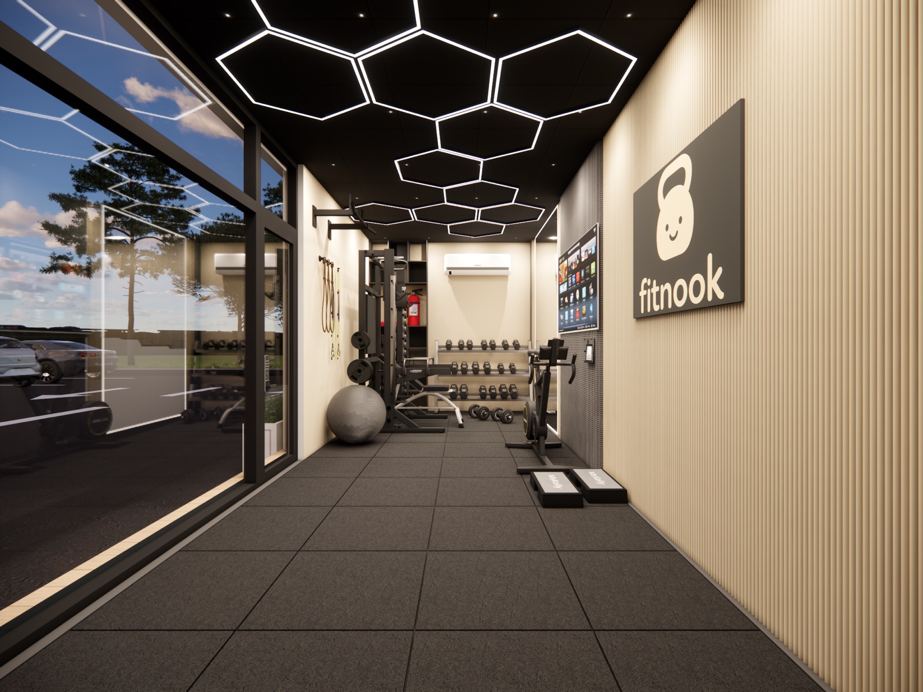 Interior view of a fitnook pod showing dumbbells, half-rack, hexagon ceiling lights, and panoramic window